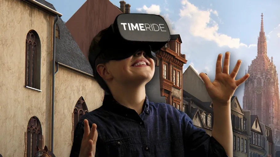 Junge trägt VR-Brille, mittelalterliche Stadt im Hintergrund.