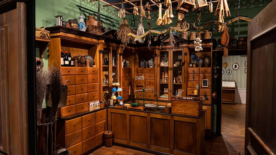 Antike Apotheke mit Holzregalen und Kräutern.