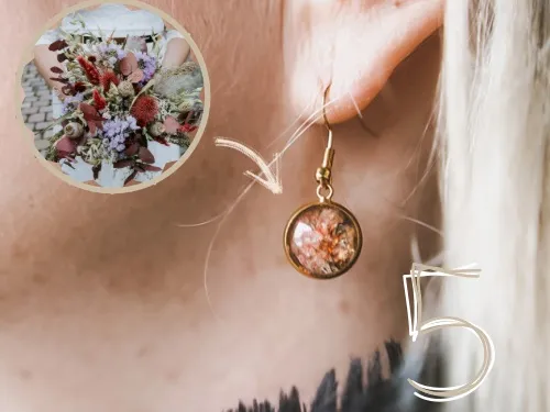 Ohrringe mit getrockneten Blumen hängen am Ohr einer Person.
