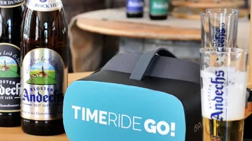 VR headset and Andechs beer bottles on table.