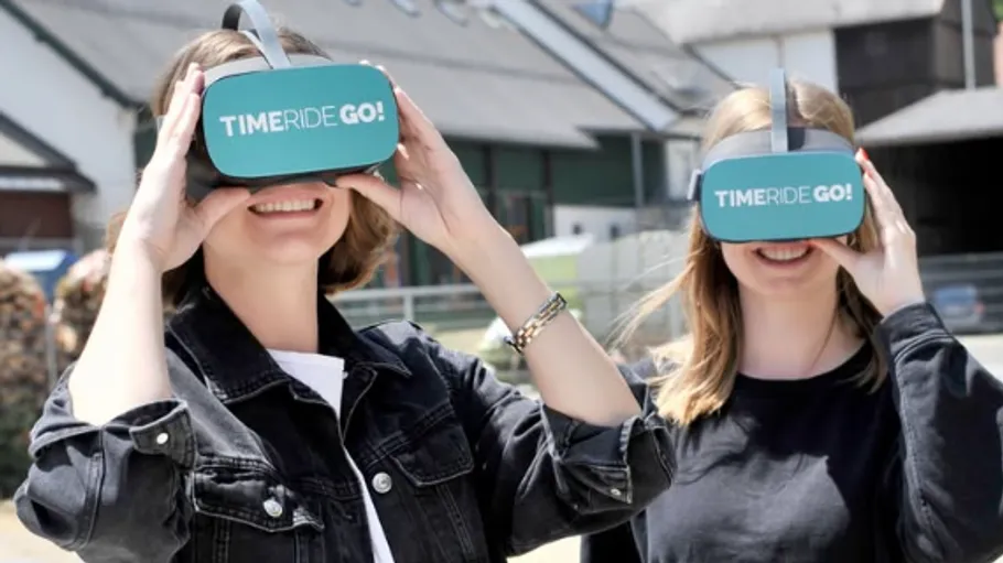 Two people wearing VR headsets outdoors.