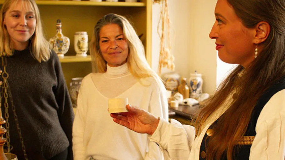 Three women talking in a pottery shop.