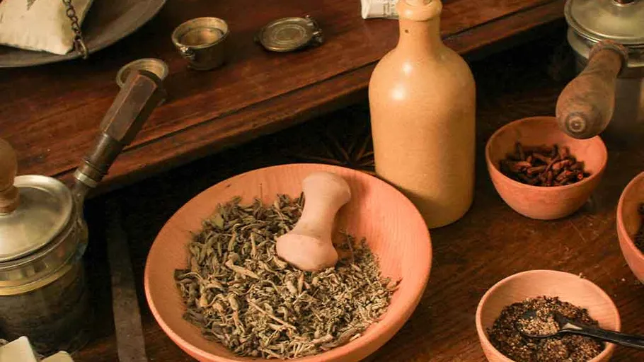 Herbs and spices in bowls on wooden table.