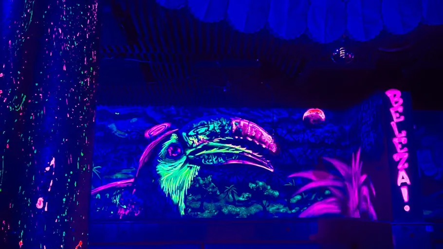 Neon toucan mural with vibrant jungle backdrop.