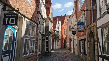 Narrow cobblestone street with colorful old buildings.