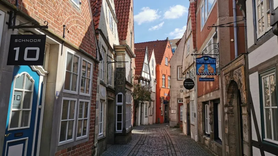 Schmale Kopfsteinpflasterstraße mit bunten alten Gebäuden.