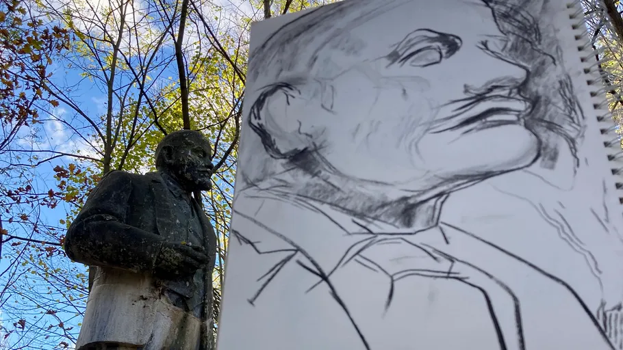 Statue neben detaillierter Bleistiftzeichnung im Freien.