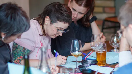 Personen schreiben Notizen an Tisch mit Getränken.