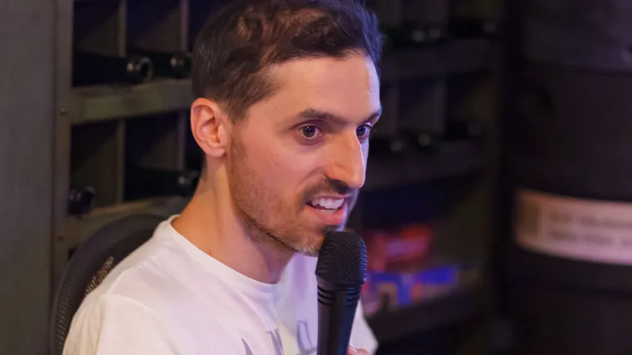 Man speaking into a microphone indoors.