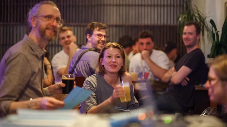 People sitting, talking, and drinking in a bar.