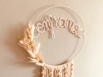 Dekorative Wandkunst zeigt das Wort `confianza` mit Trockenblumen.