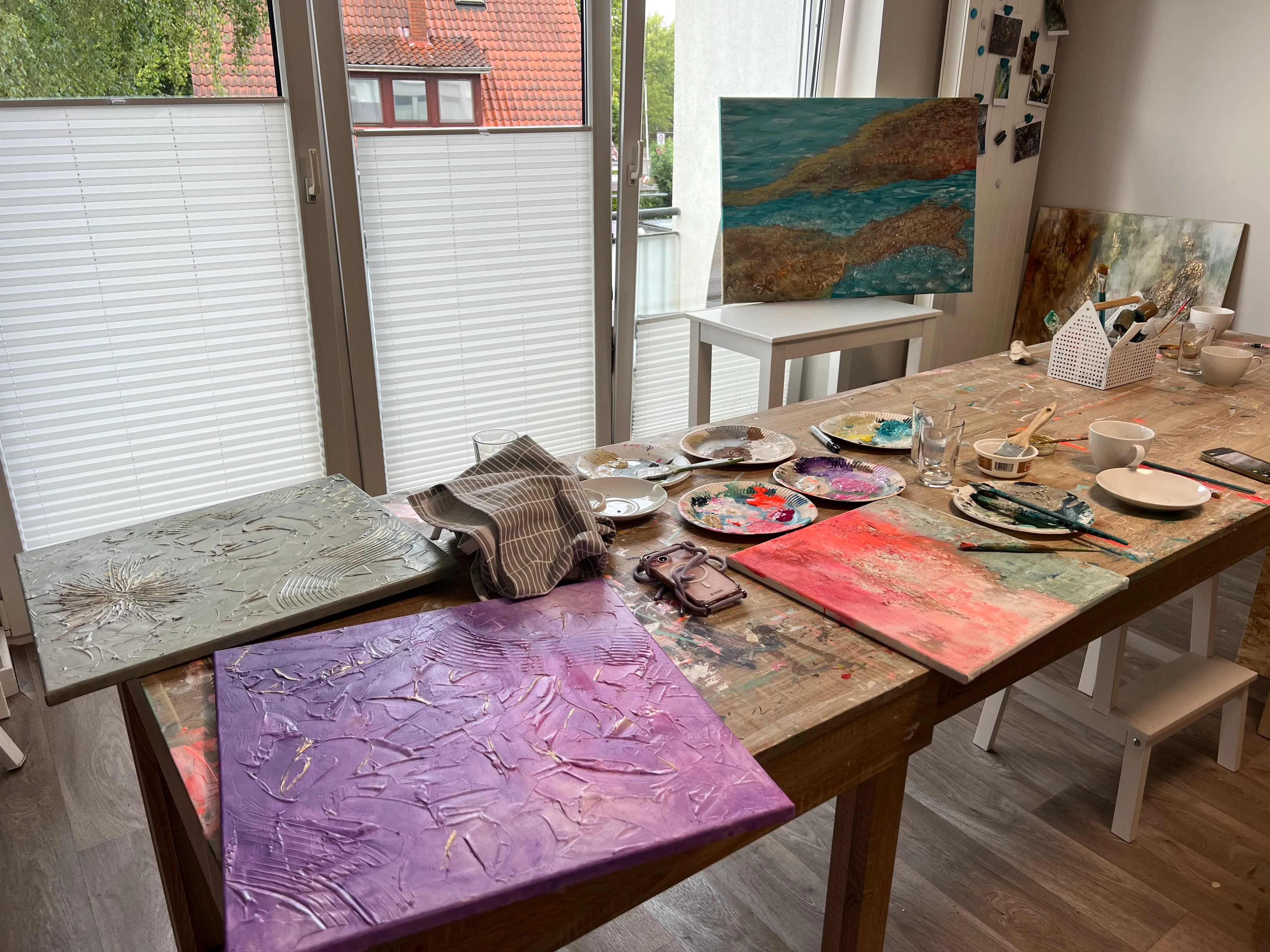 Malkunststudio mit Leinwänden auf Holztisch.