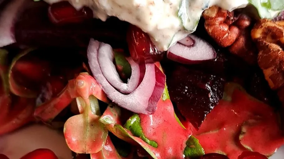 Salat mit Zwiebeln, Nüssen und Sahnedressing.