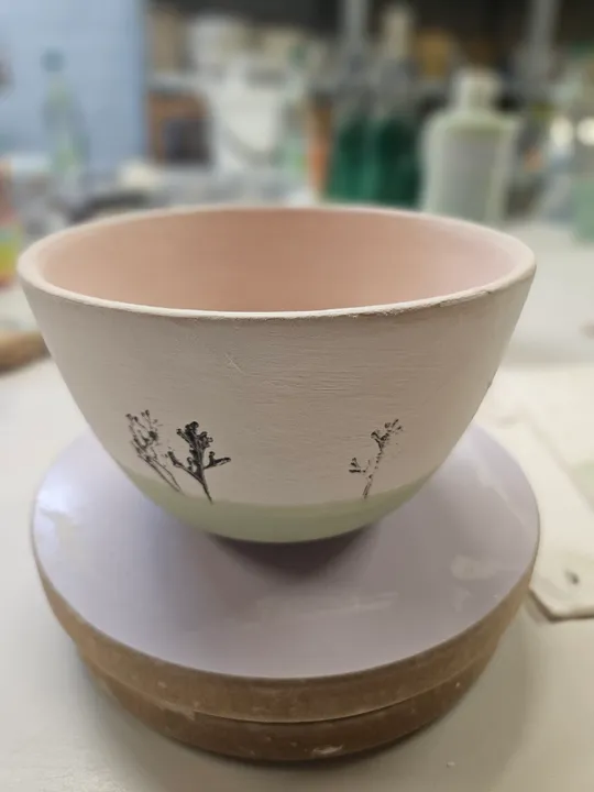 Ceramic bowl with floral design on turntable.