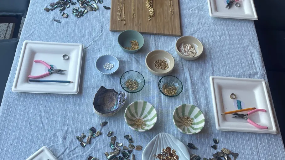 Jewelry-making tools and materials on table.