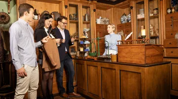 Personen interagieren in einer alten Apotheke.