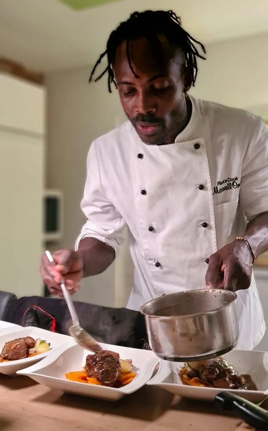 Chef plating food in a kitchen.