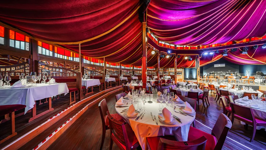Elegant dining area under a colorful tent.