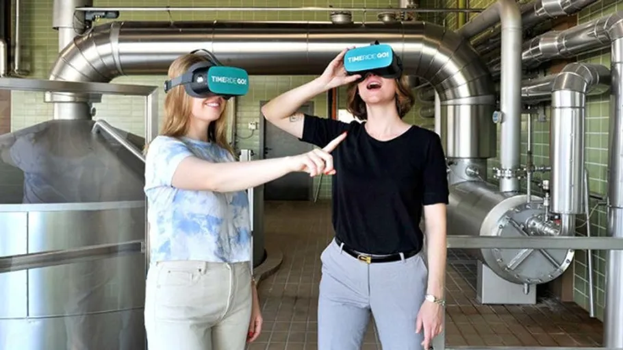 Zwei Personen tragen VR-Brillen in industrieller Umgebung.