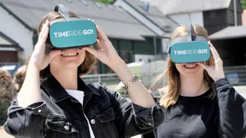 Two people using VR headsets outdoors.