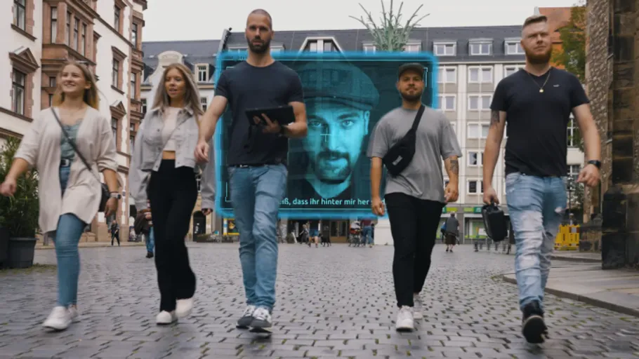 Five people walking on cobblestone street.
