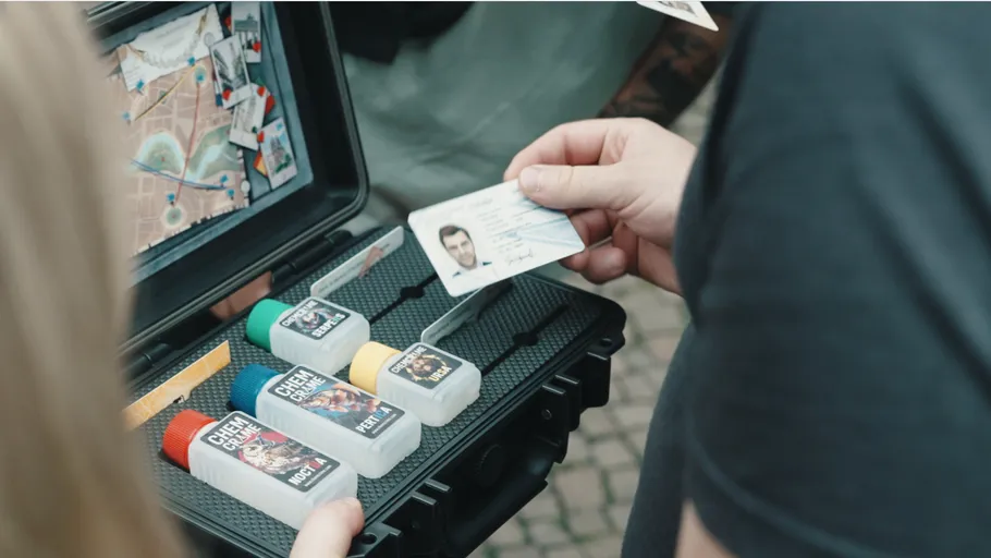 People examining spy kit with map and ID.