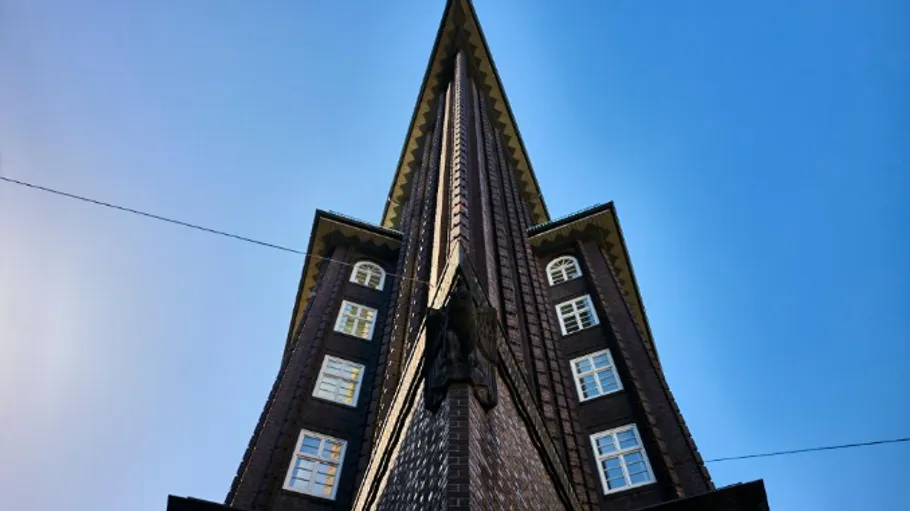 Spitzwinkliges Gebäude vor klarem blauen Himmel.