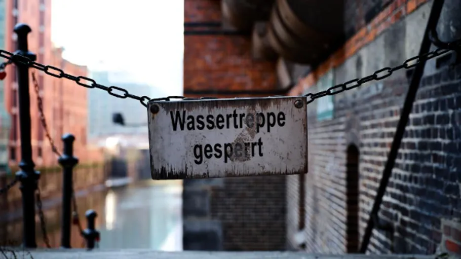 Sign reading 'Wassertreppe gesperrt' on fence.