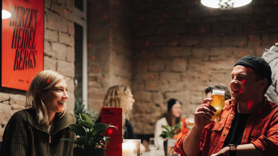 Menschen lächeln und trinken in einer gemütlichen Bar.