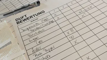 Duftbewertungsbogen mit Notizen und Stift.