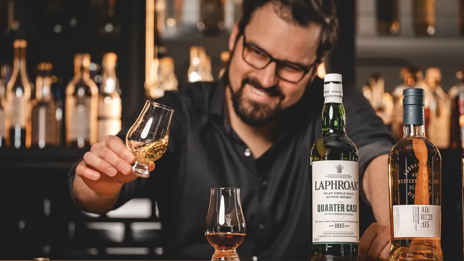 Mann genießt Whisky an der Bartheke.