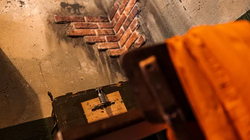 Ziegelmauer mit altem Koffer und orange Stoff.