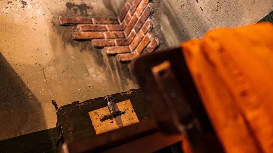 Ziegelmauer mit altem Koffer und orange Stoff.