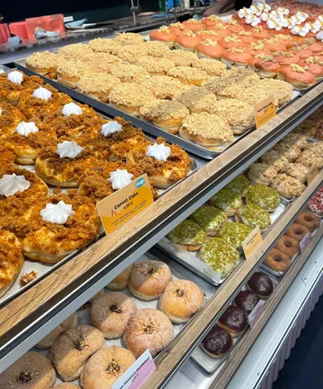 Assorted donuts on display in a bakery.