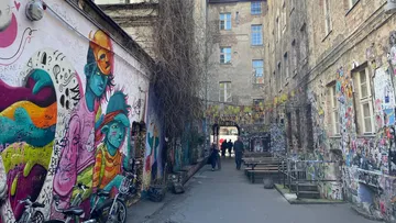 Colorful graffiti in narrow urban alleyway.