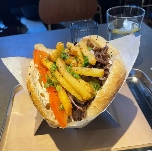 Sandwich mit Pommes und Gemüse auf Tisch.