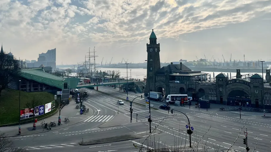 Uhrturm am Wasser mit bewölktem Himmel.