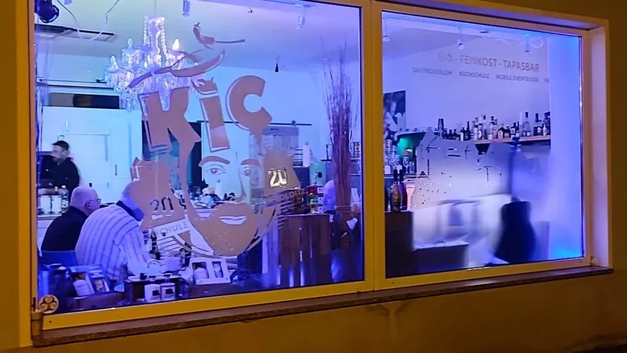 Restaurant-Innenraum durch Fenster bei Nacht gesehen.