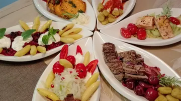 Five plates of diverse gourmet food displayed.