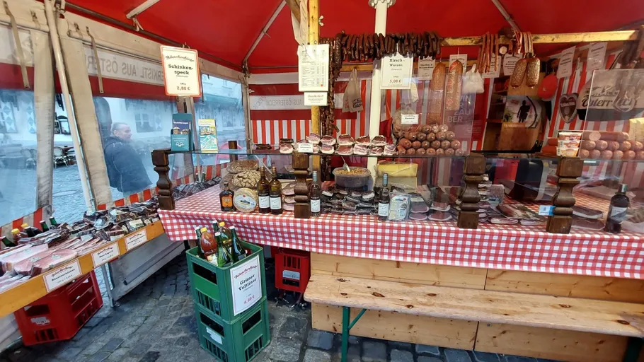 Marktstand mit Fleischwaren und Flaschengetränken ausgestellt.