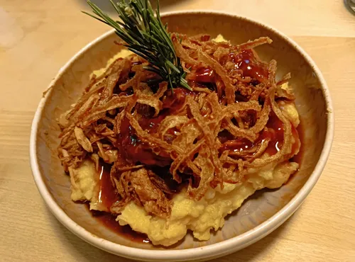 Kartoffelpüree mit knusprigen Zwiebeln in Schüssel.