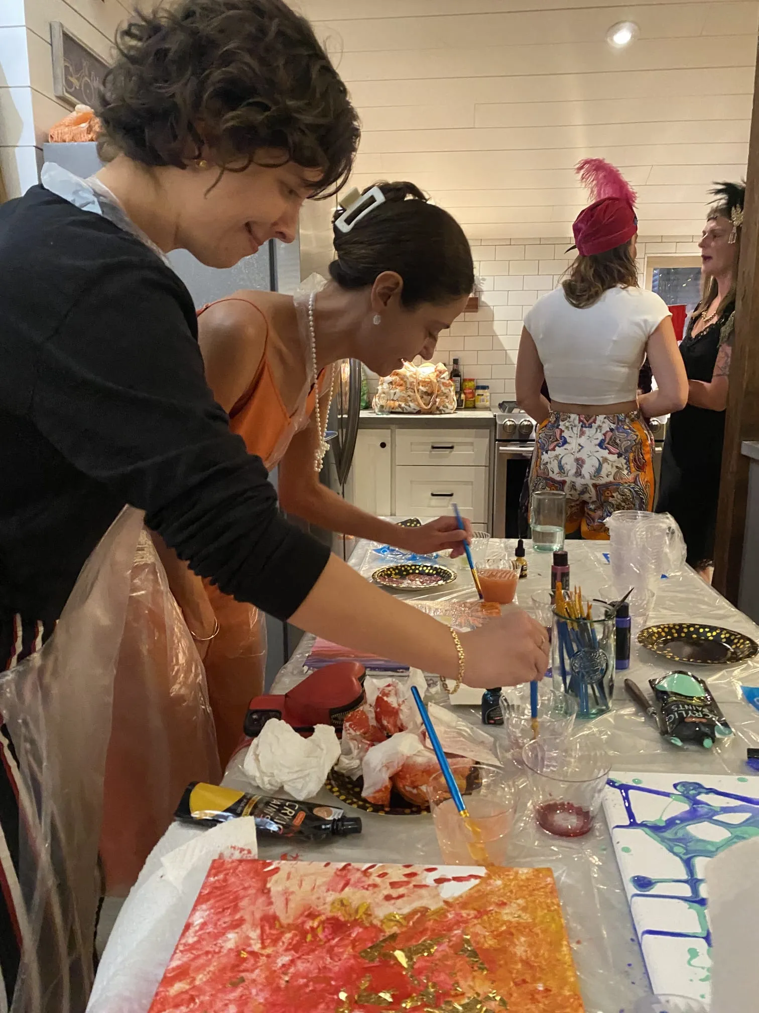 Menschen malen Kunst in einer belebten Küche.