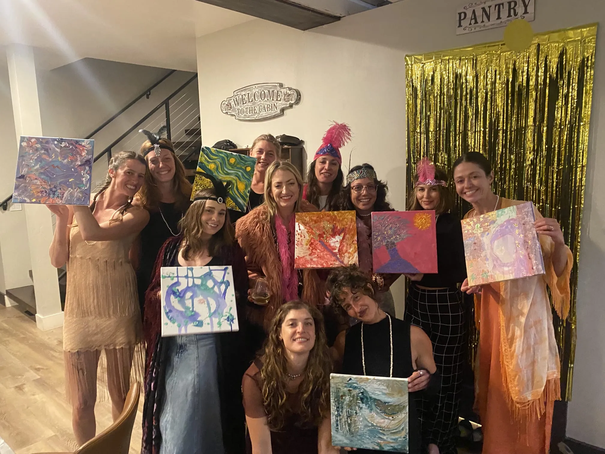 Gruppe hält Gemälde, in Themenkleidung gekleidet.