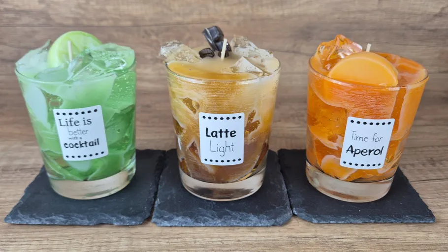Three cocktail candles on slate coasters.