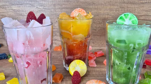 Drei bunte Getränke mit Obstgarnituren.