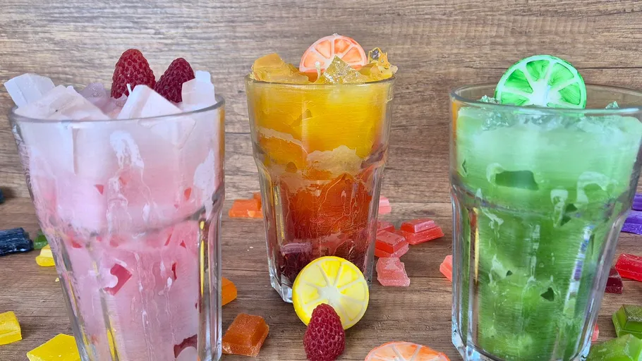 Drei bunte Getränke mit Obstgarnituren.
