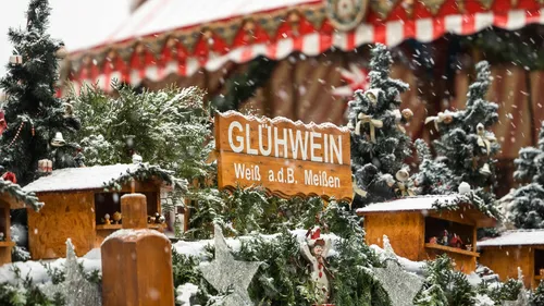 Glühweinschild inmitten verschneiter Weihnachtsdeko.