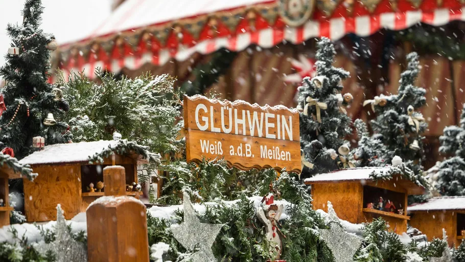 Glühweinschild inmitten verschneiter Weihnachtsdeko.