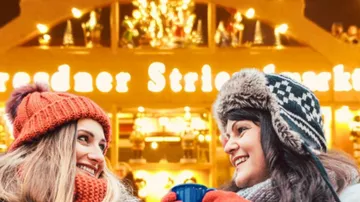 Zwei Frauen lächeln auf Wintermarkt.