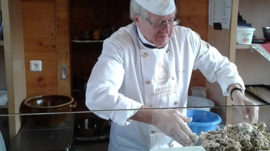 Baker prepares dough in a rustic kitchen.